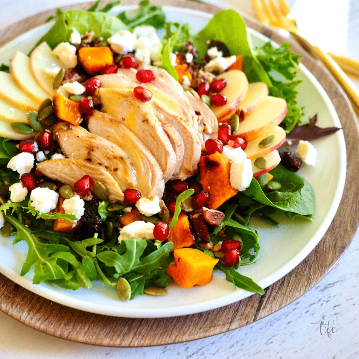 Fall Harvest Chicken Salad on a pretty plate with feta cheese, butternut squash, chicken, apples and nuts.