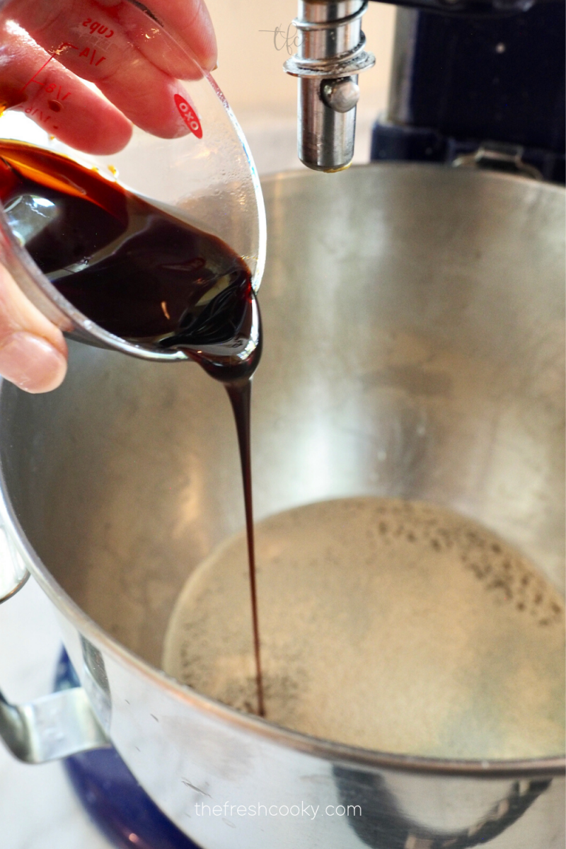 Pouring in molasses to pretzel bites yeast mixture.