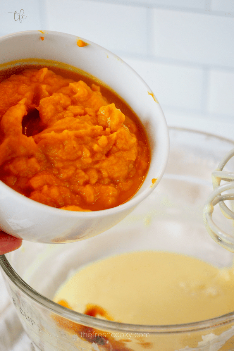 Adding pumpkin puree to pumpkin pie bar mixture. 