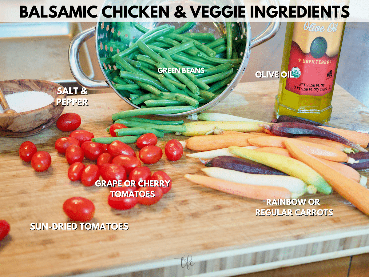 Ingredients for the vegetable portion of the balsamic chicken sheet pan and veggies, showing salt and pepper, green beans, olive oil, rainbow carrots and grape tomatoes.