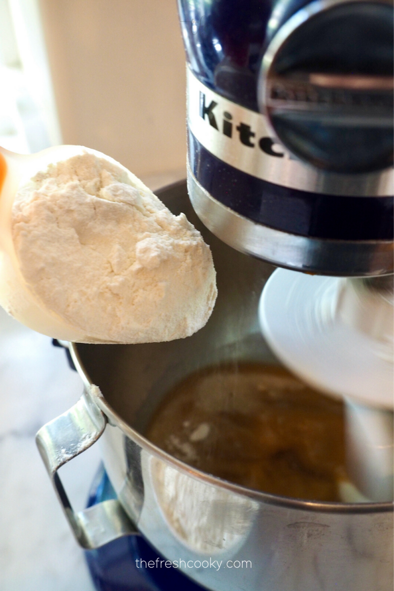 Adding flour to pretzel dough mixture in mixer. 
