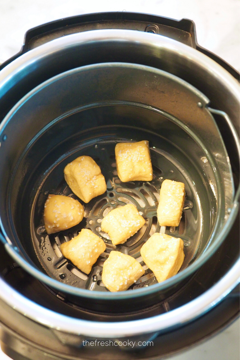 Uncrowded pretzel dough bites in air fryer ready to fry. 