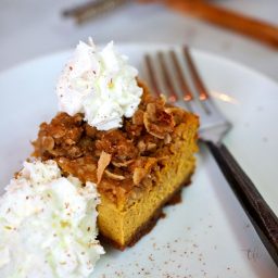 Pumpkin Streusel Cheesecake Bars with pretty dollops of whipped cream with fork.