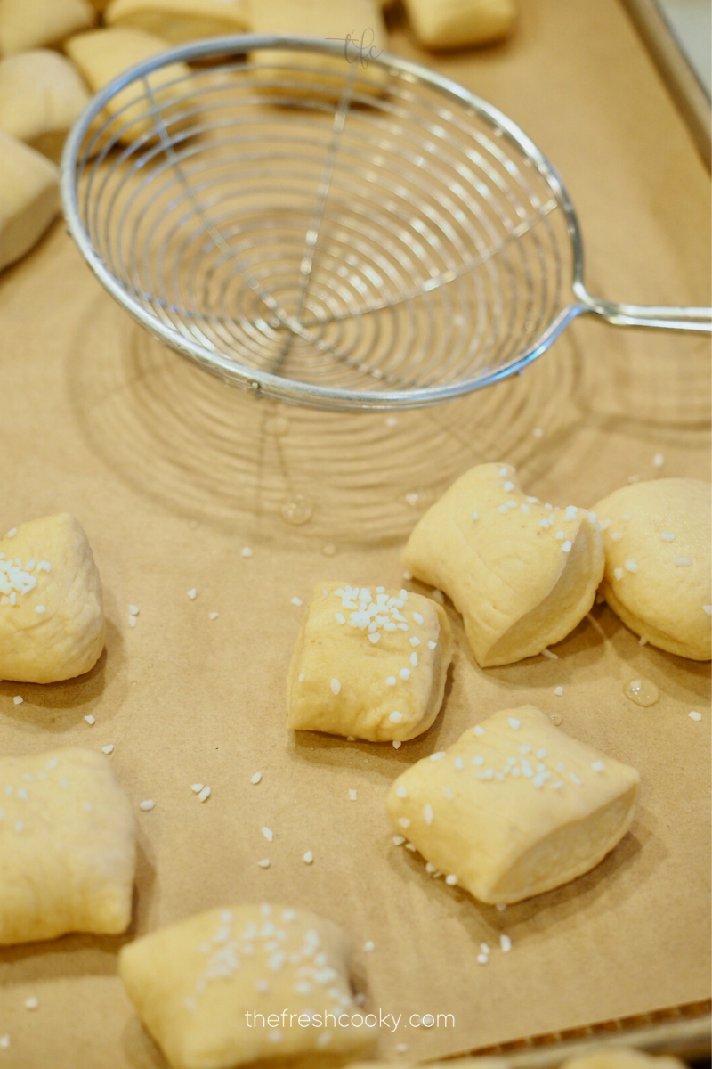 Pretzel bites out of baking soda bath and sprinkled with pretzel salt. 