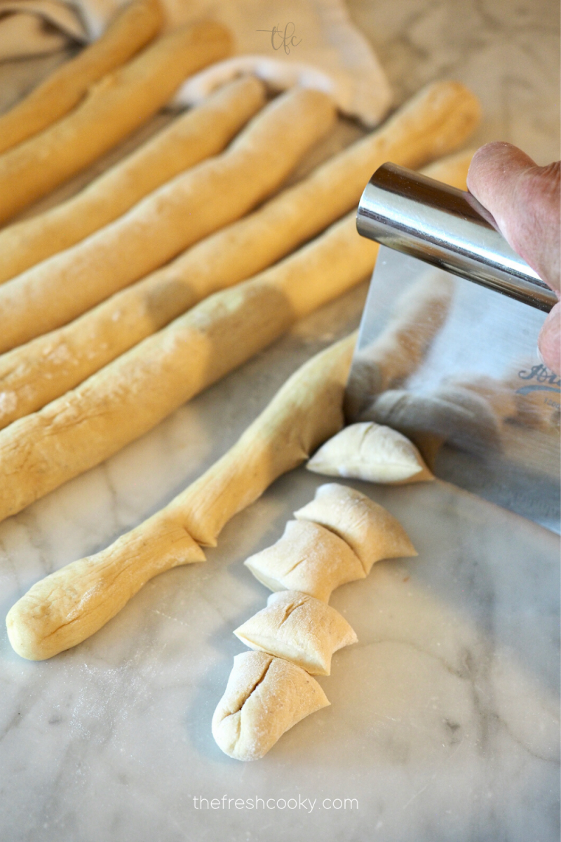 Cutting pretzel ropes into 1 inch pieces. 