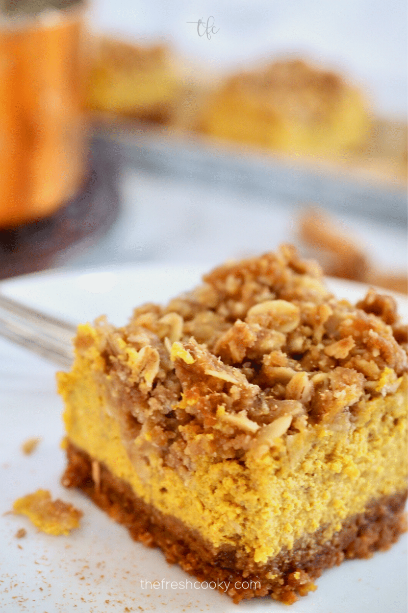 A pumpkin bar with streusel topping unfrosted sitting on a plate.