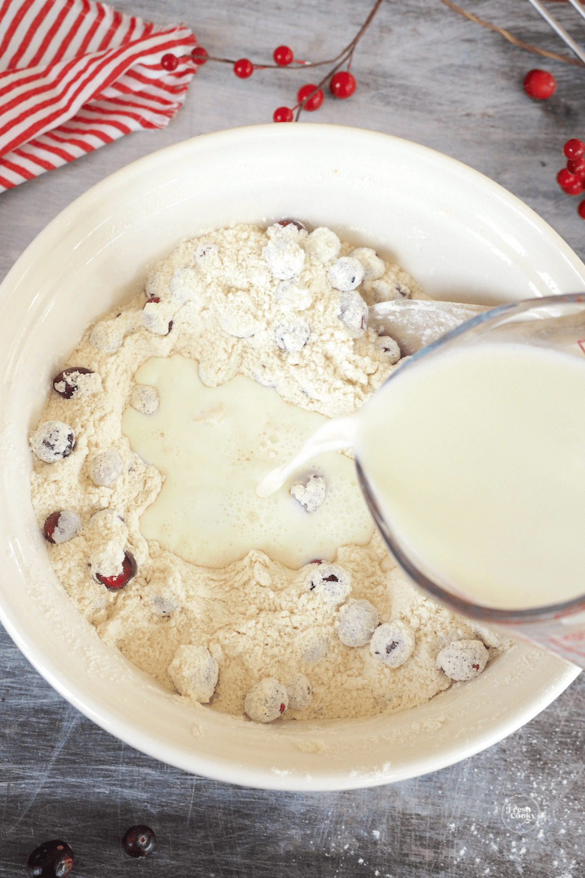 Pouring milk into dry ingredients for cranberry cake. 