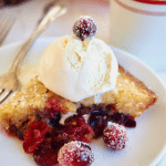 Nantucket Cranberry Christmas pie on a plate with a scoopo of vanilla ice cream and sugared cranberries on top.