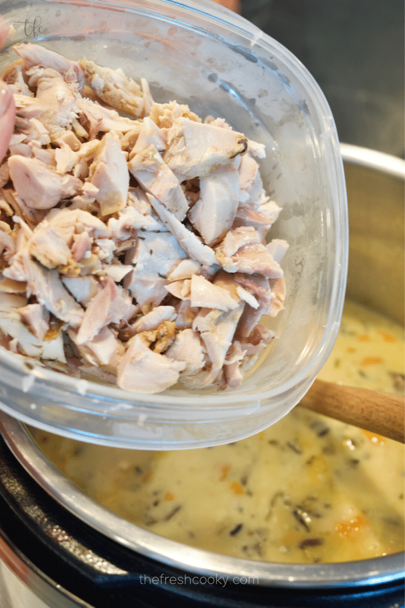 Pouring in chicken to instant pot to make chicken and wild rice soup. 