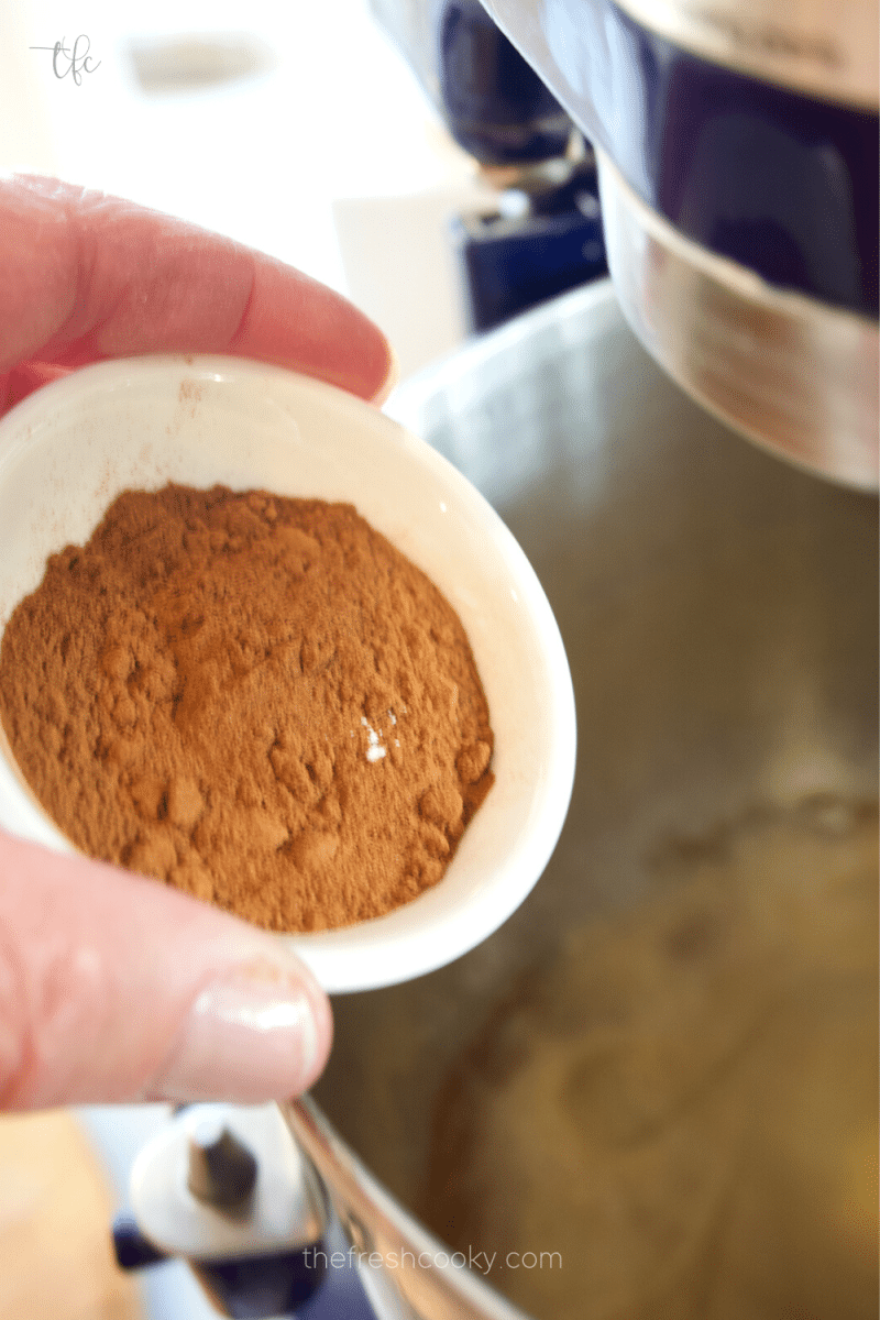 Adding cinnamon to batter for Pfeffernusse cookies. 