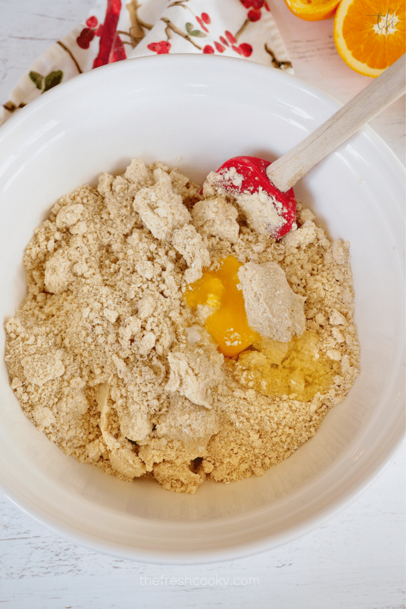 Mixing an egg into the oatmeal crunch mixture in large bowl. 