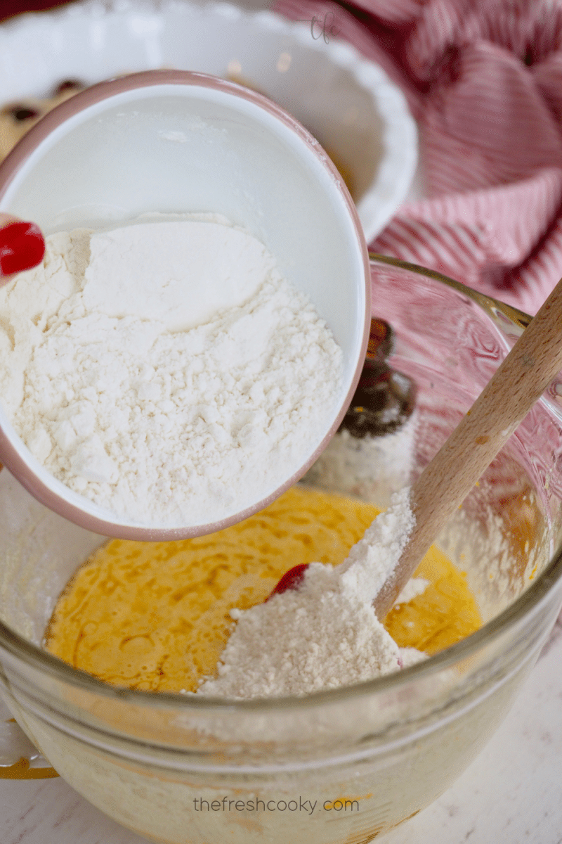 Adding flour to cranberry pie batter. 