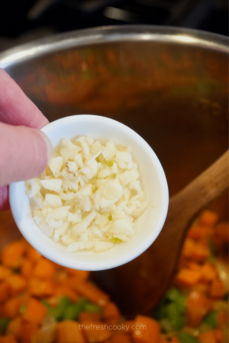 Adding garlic to instant pot for chicken and wild rice soup.