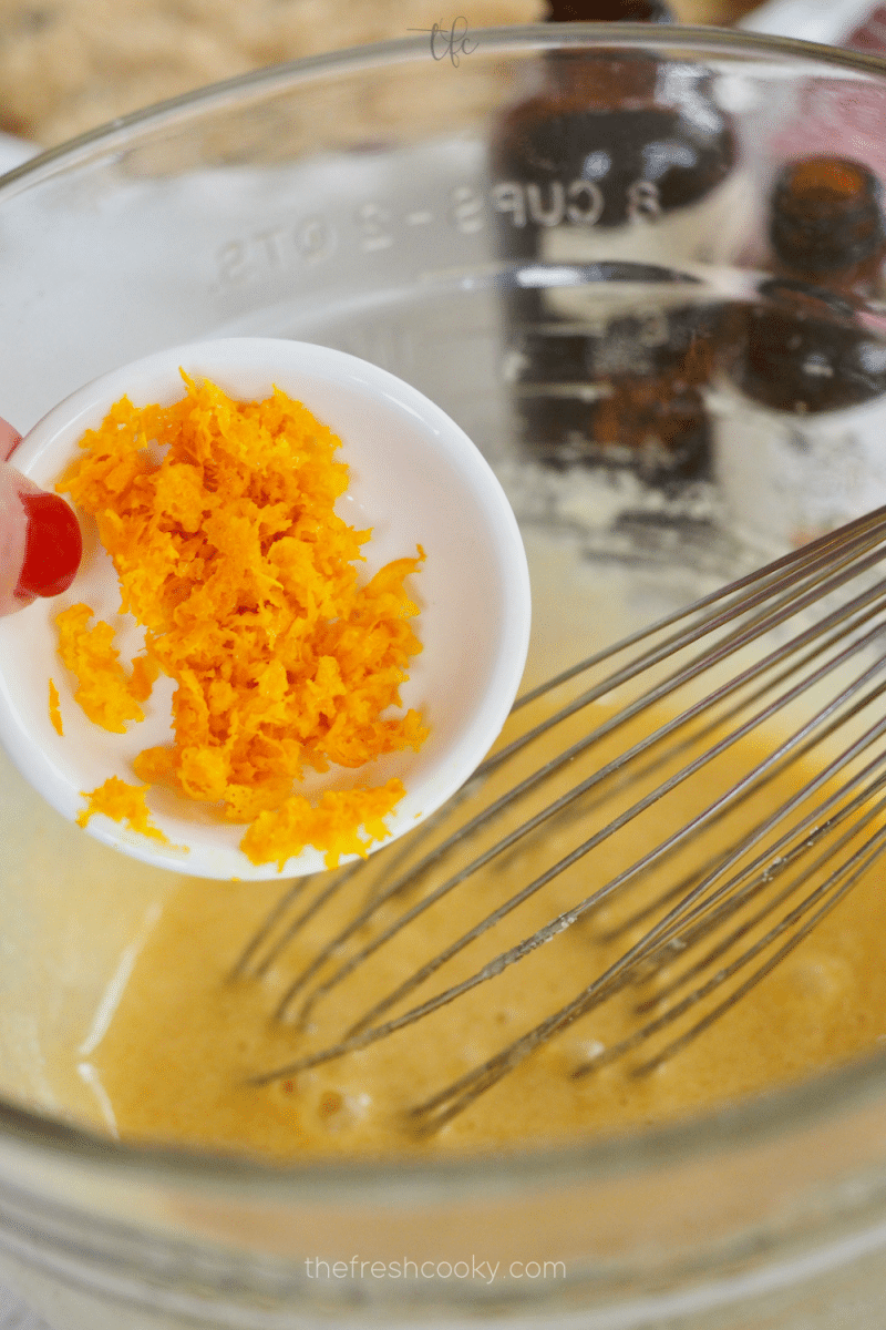 Adding orange zest (optional) into cranberry pie batter. 