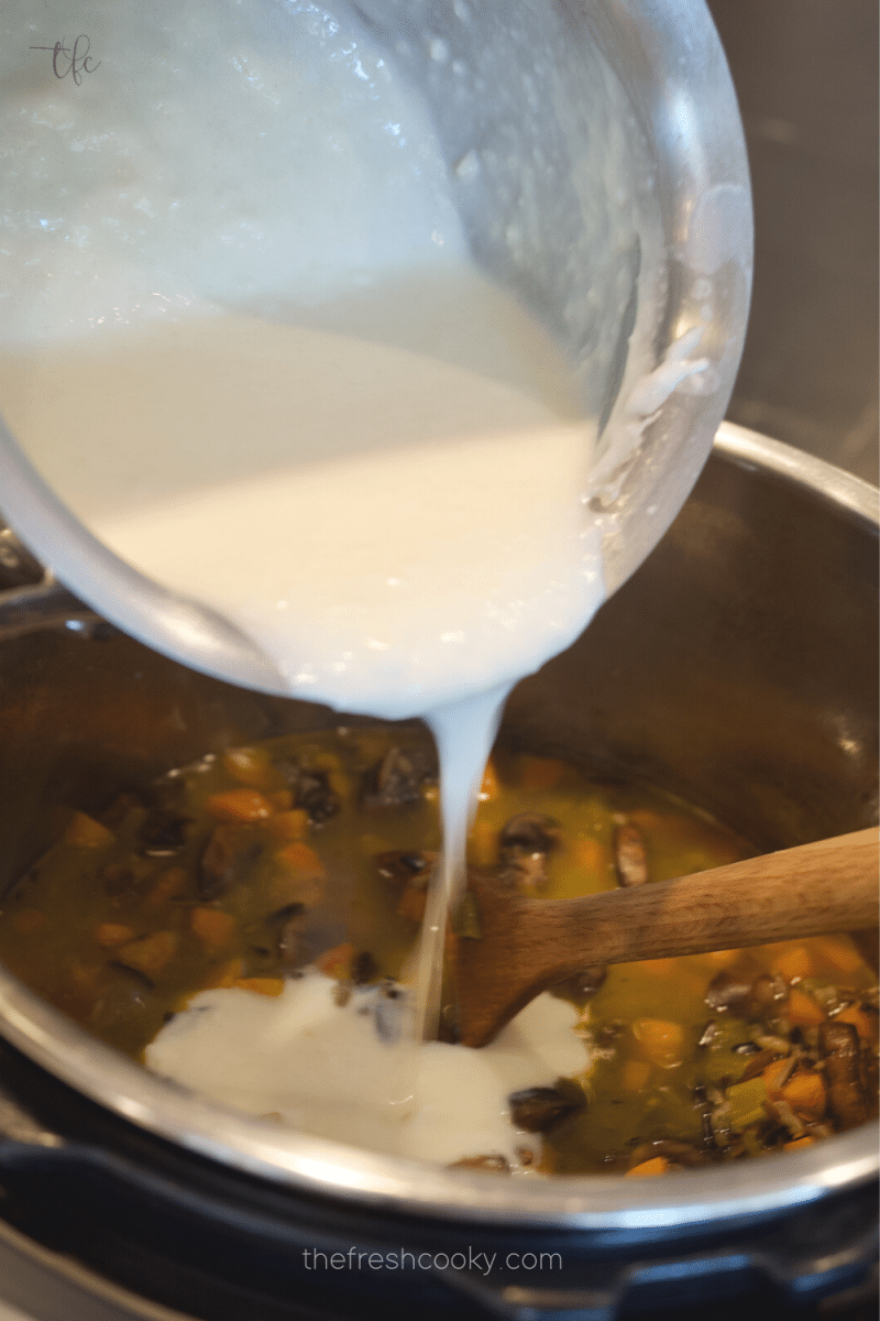 Pouring thick roux into cooked chicken and wild rice soup in Instant Pot. 