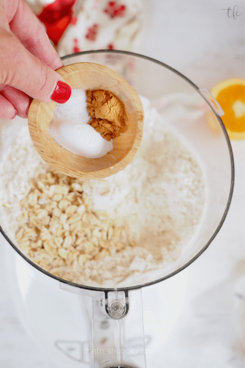 Adding spices and baking powder to oats and flour in food processor for cranberry oatmeal crumbs. 