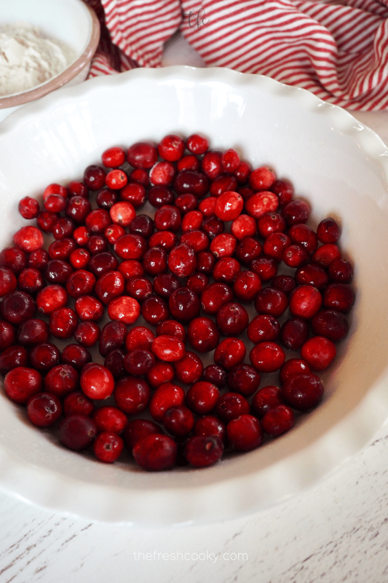 fresh cranberries laid in pie plate for cranberry tart. 