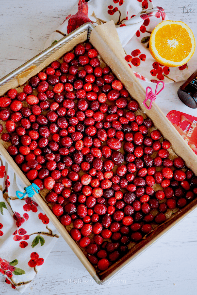 Cranberries spread evenly in 9x13 inch pan for cranberry crunch bars. 