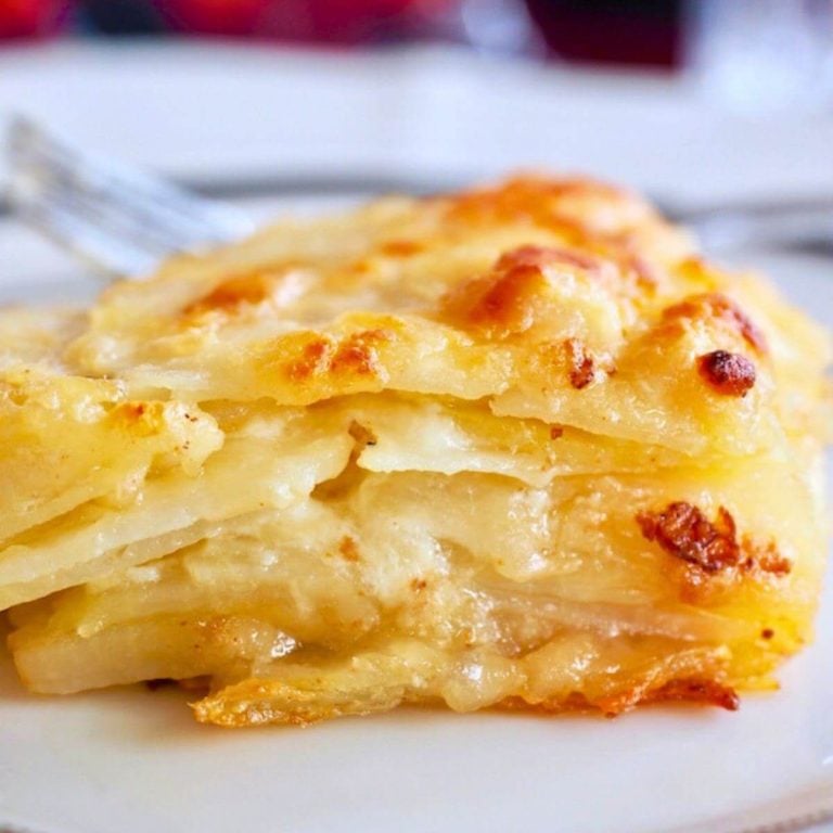 Slice of layered potatoes au gratin on plate.