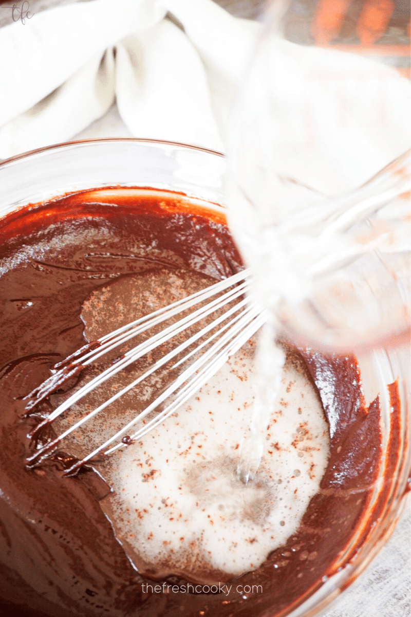 Pouring champagne into chocolate ganache for champagne truffles. 