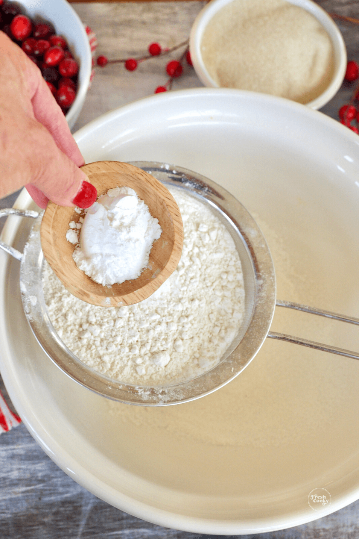 Sifting flour and baking powder into bowl.