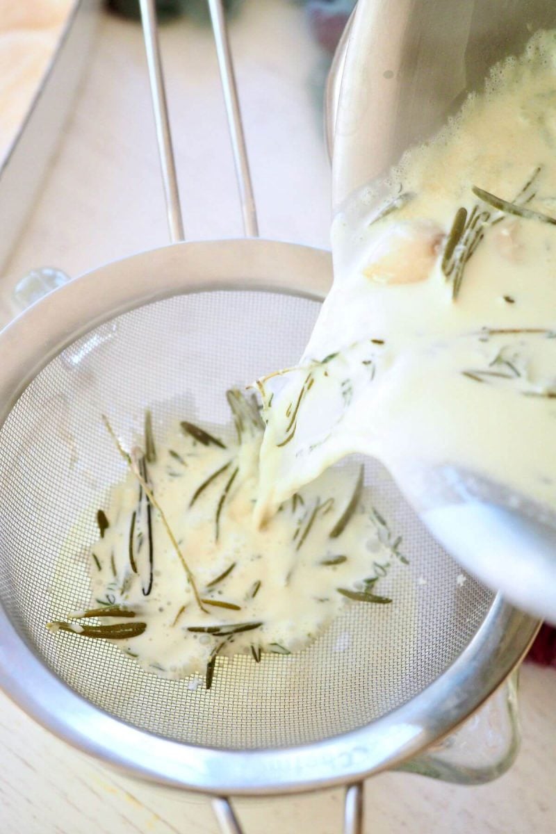 Pouring herbed cream through sieve.