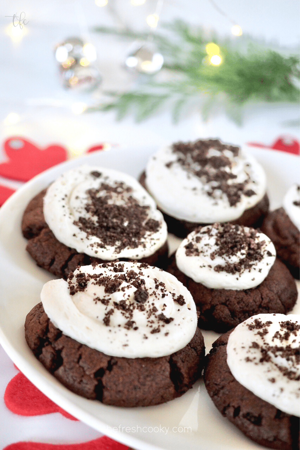 Holiday image of Copycat Crumbl Oreo Cookies with plate filled with frosted giant chocolate cookies.