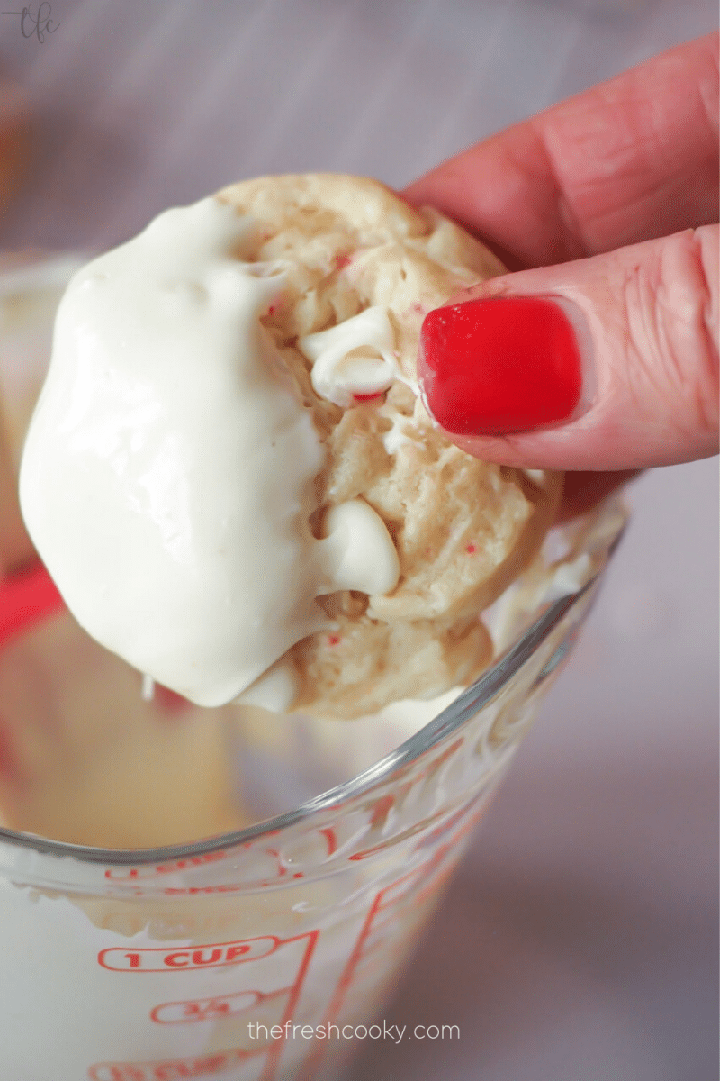 Dipping white chocolate peppermint cookies into white chocolate. 