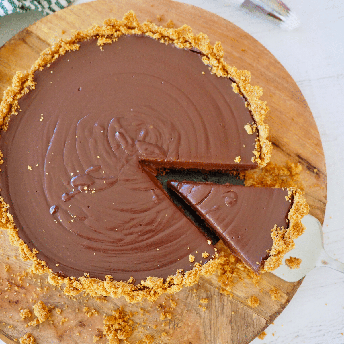 No bake chocolate pie with graham cracker crust with wedge removed on pie server.