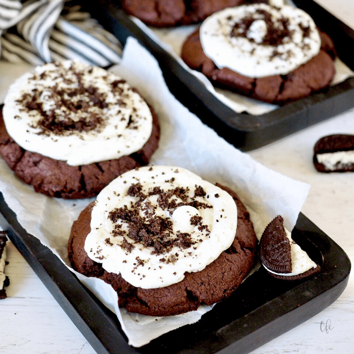 Oreo Crumbl Cookie image with 3 giant cookies frosted with buttercream and sprinkled with Oreo crumbs.