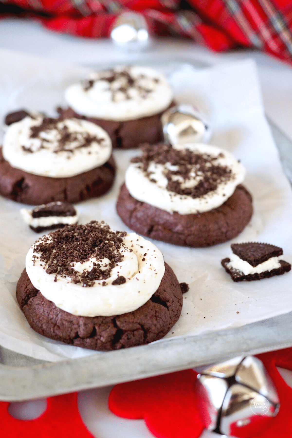 Holiday Copycat Oreo Crumbl Cookies on tray with silver bells and crushed Oreos. 