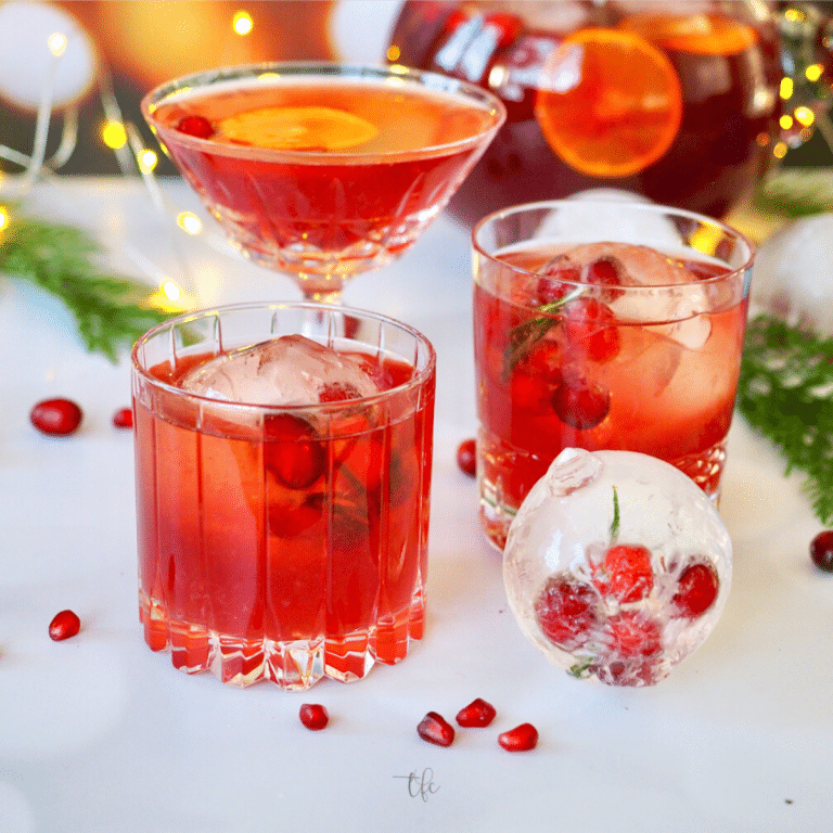 Best Thanksgiving Punch pomegranate vodka punch in three different crystal glasses with decorative ornament ice cubes.