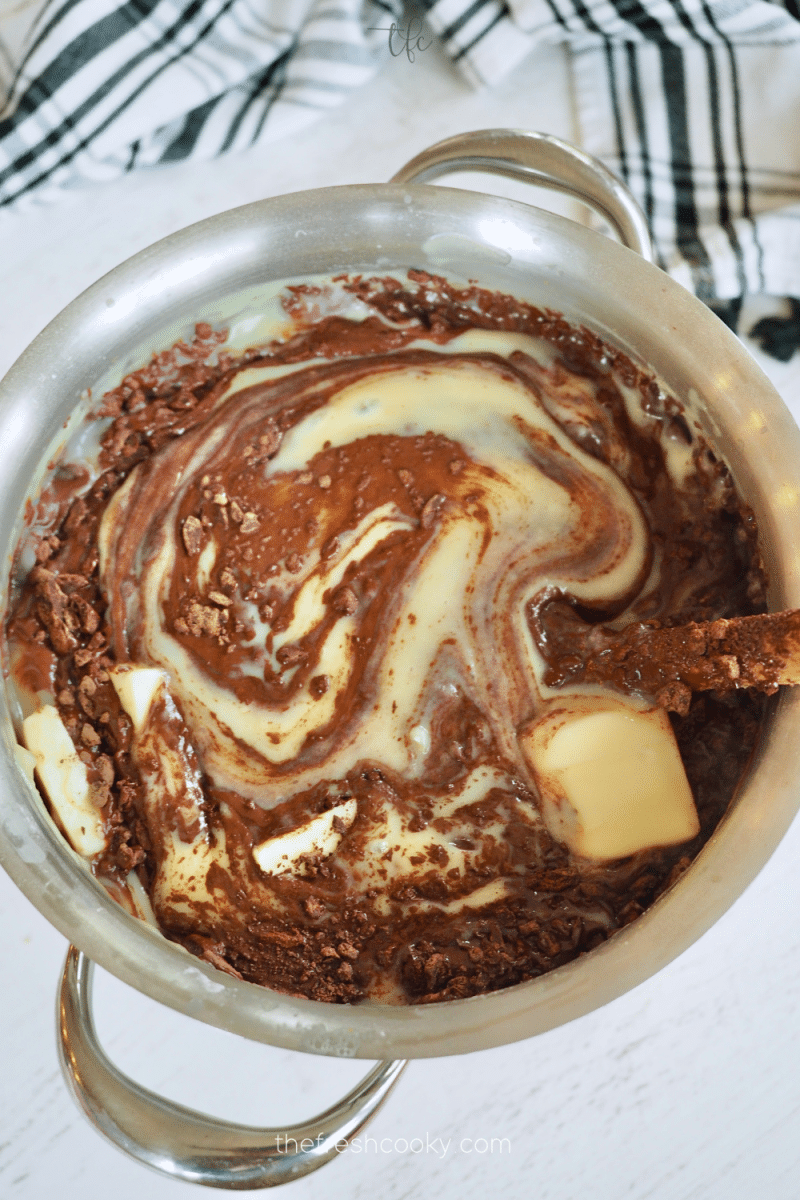Stirring chocolate, vanilla and butter into hot pudding mixture until combined