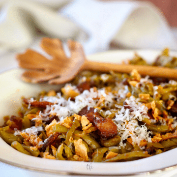 Southern-Style green beans close-up with parmesan cheese, bacon and crispy onions.