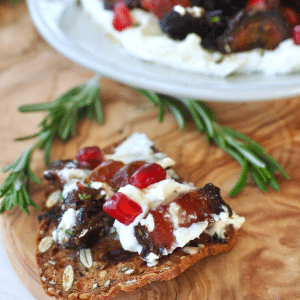 Whipped Goat Cheese with bacon and dates spread onto rustic cracker.