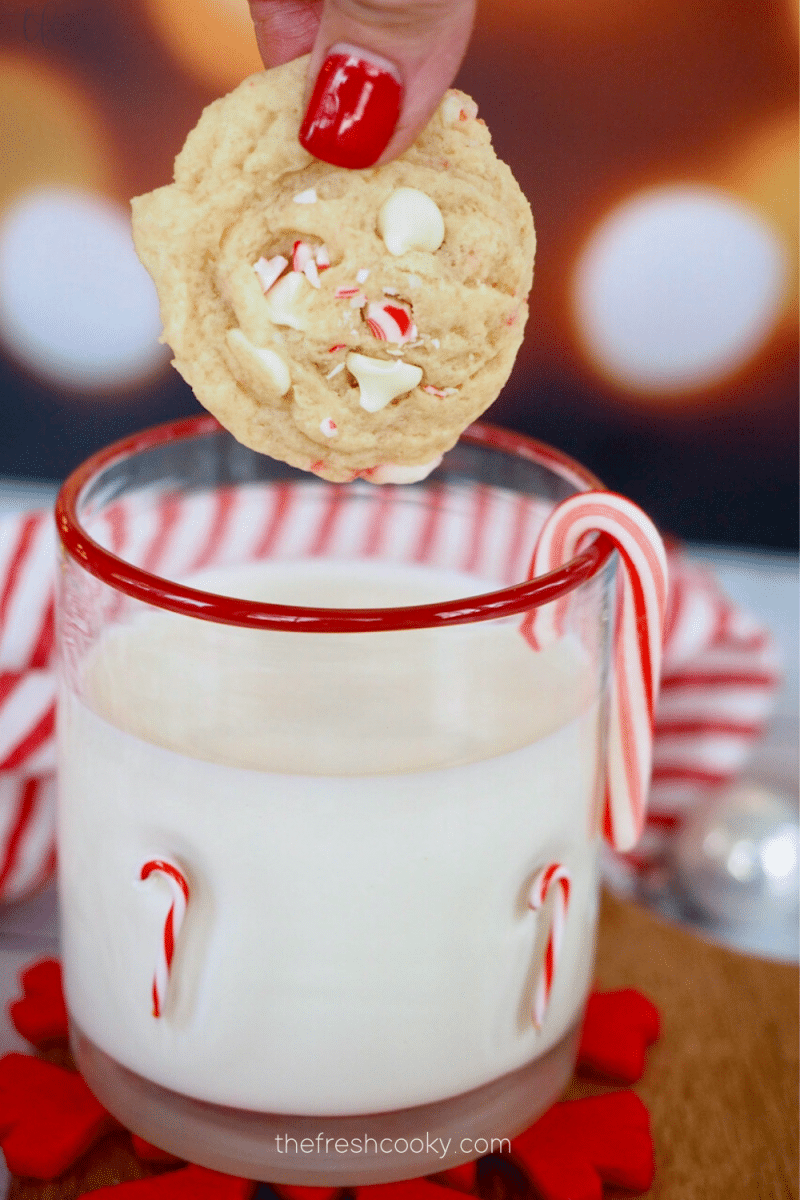 White Chocolate Peppermint Cookie being dunked into a glass of milk.
