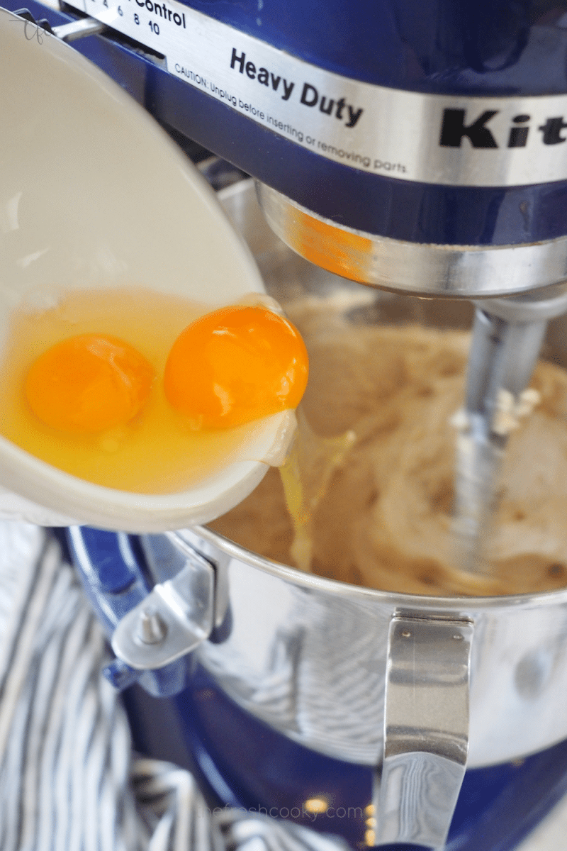 Adding eggs to creamed butter and sugar mixture for Oreo Crumbl Cookies.