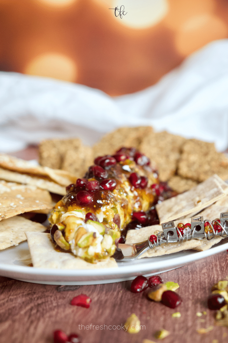 Goat cheese appetizer pistachio-crusted with fig jam and hot honey with crackers.