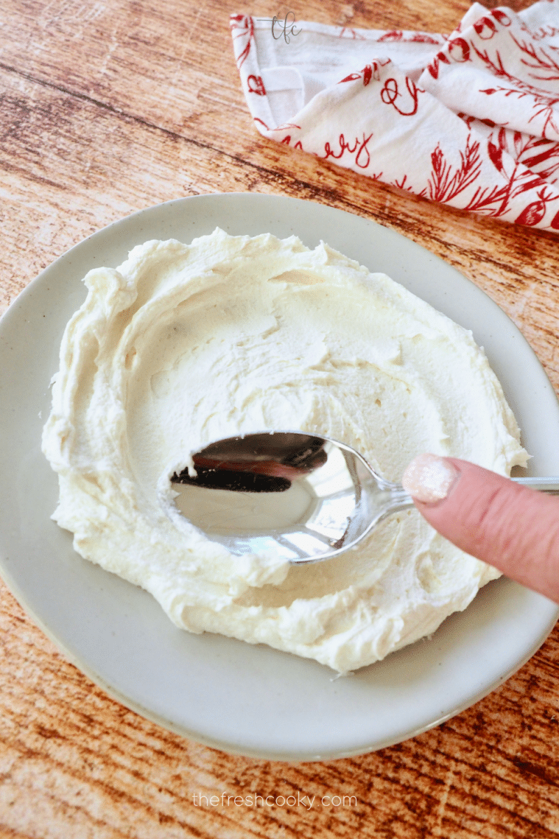 Using spoon to spread goat cheese mixture and then create troughs.