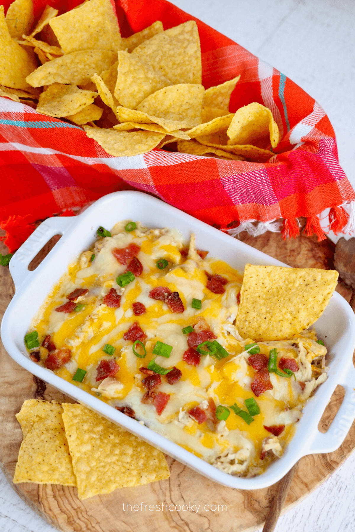 Crockpot Bacon Ranch Chicken in dish served as a dip with tortilla chips.
