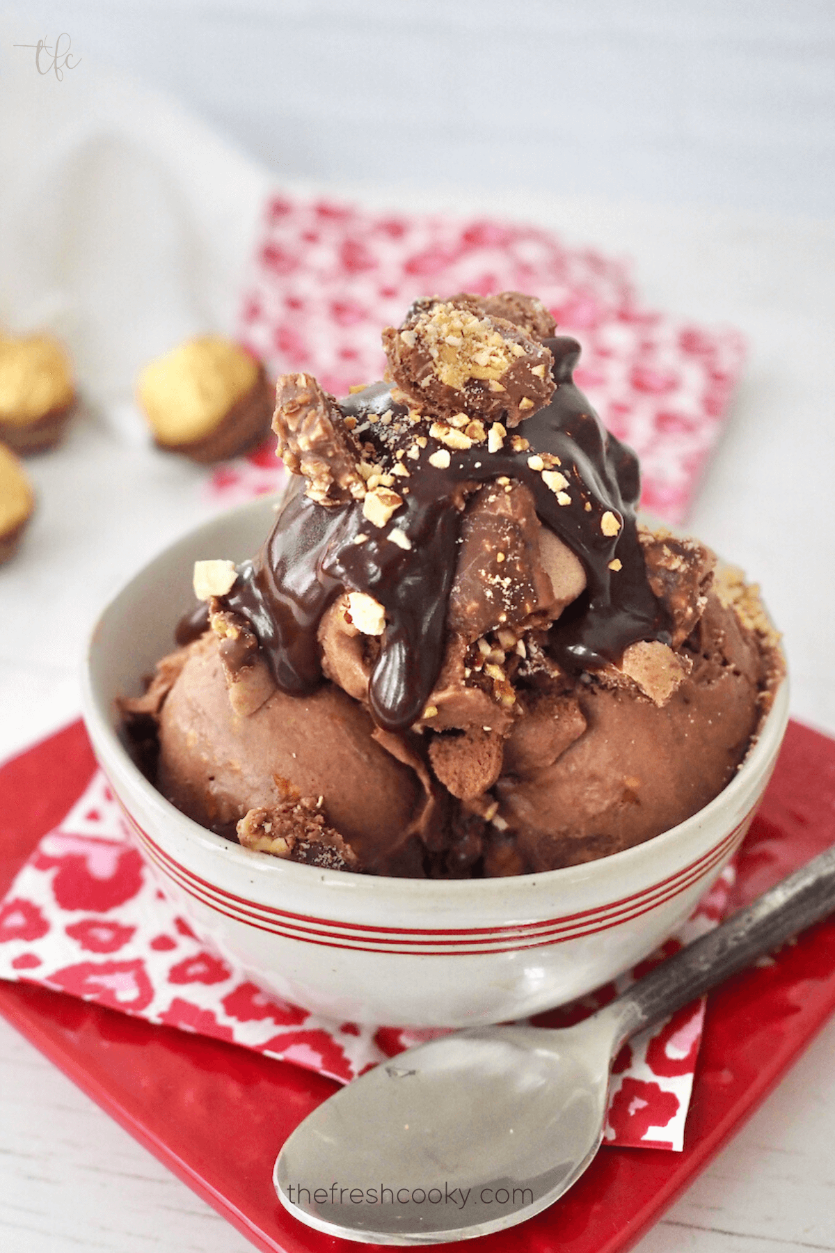 Ferrero Rocher Ice Cream in small dish with Valentine's Napkin, topped with hot fudge and crushed Ferrero Rocher chocolates.