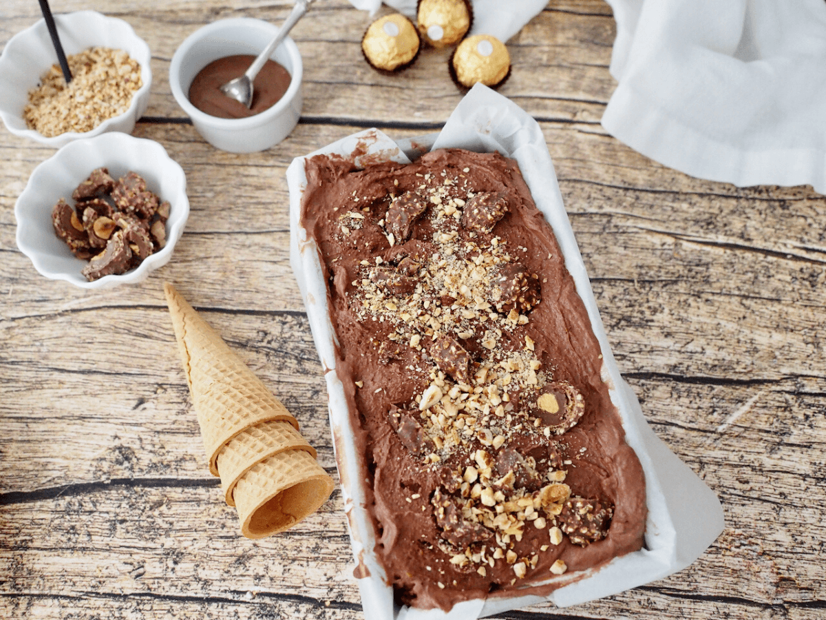 Image of Ferrero Rocher Ice Cream in loaf pan with toppings nearby.