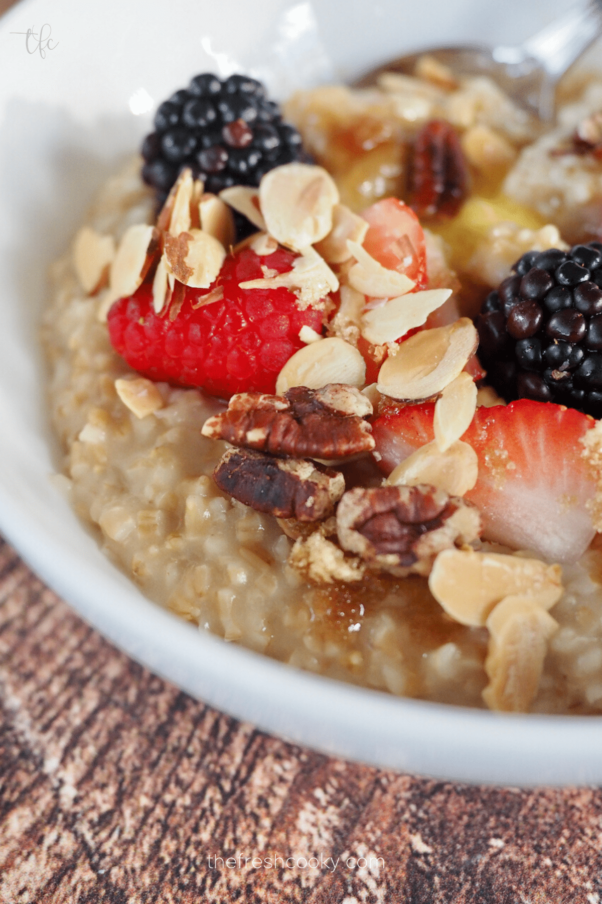 Easy Instant Pot Oatmeal Recipe close up shot with steel cut oats, almonds, berries and brown sugar. 