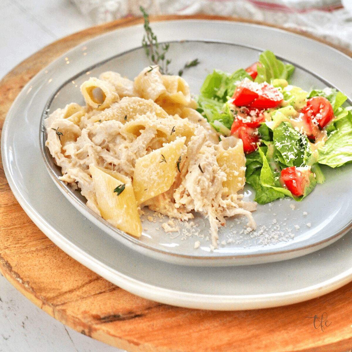 Olive Garden Crock Pot Chicken image with pasta on a plate with a green salad.