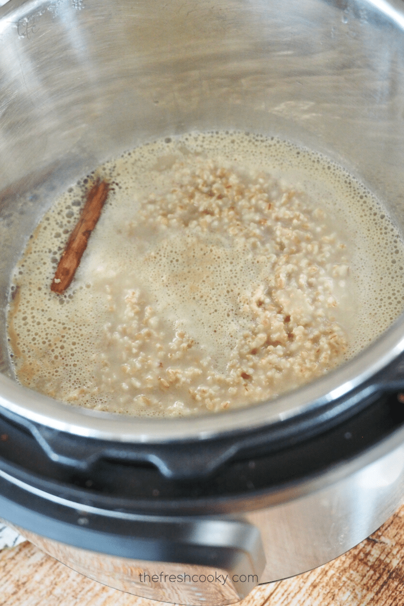 Steel cut oats in Instant Pot with cinnamon stick before final stirring after cooking. 