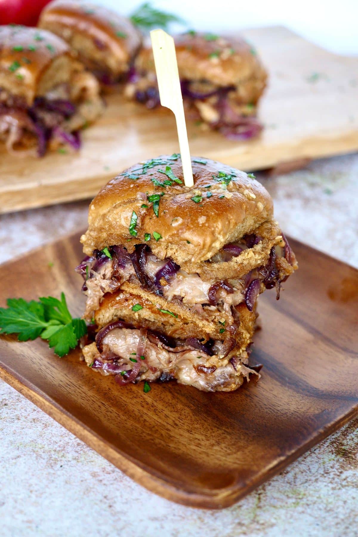 Roast beef sliders, stacked one on top of the other made with red caramelized onions.