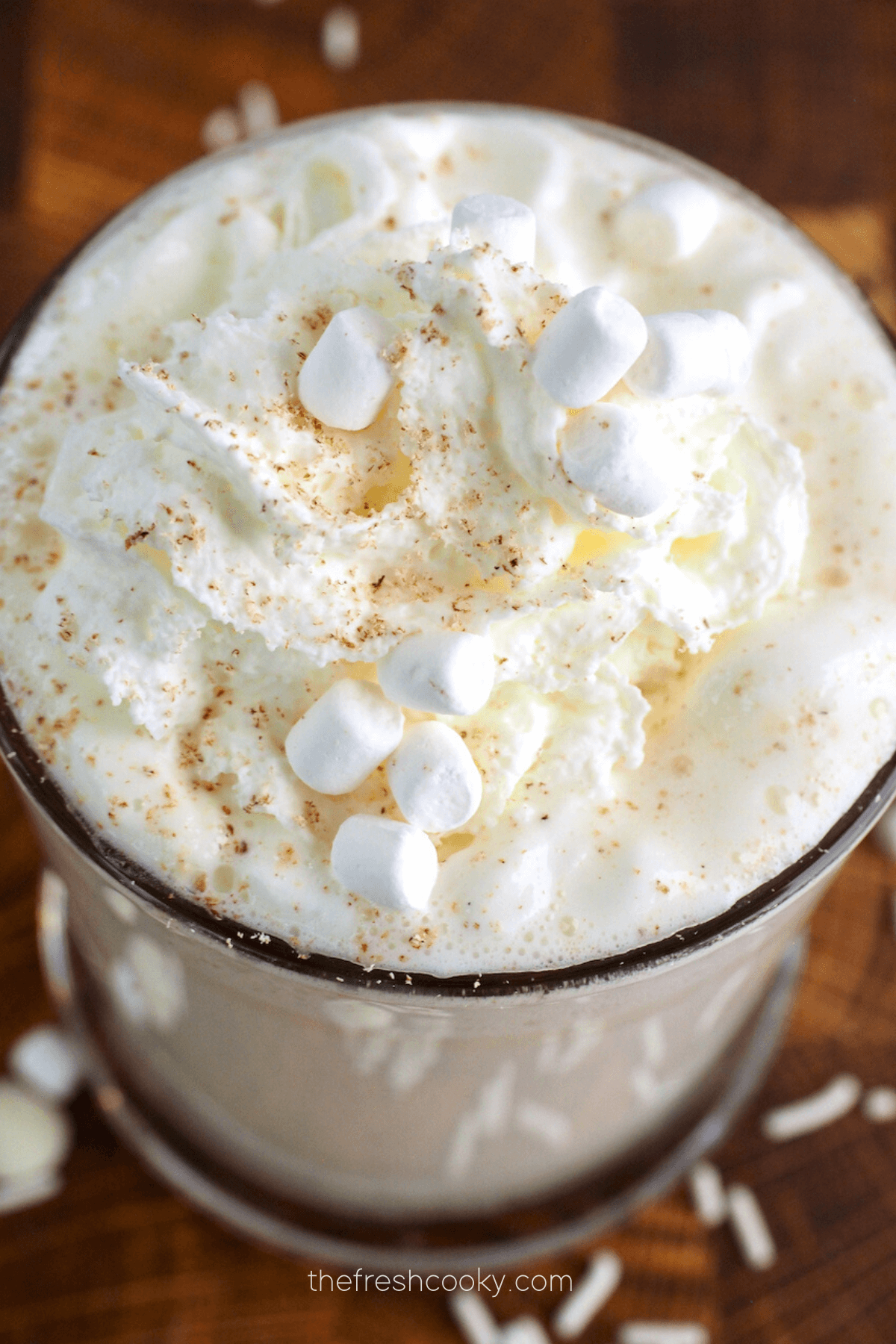 Starbucks White Hot Chocolate in glass mug, top down shot with whipped cream, mini marshmallows, sprinkles and nutmeg.