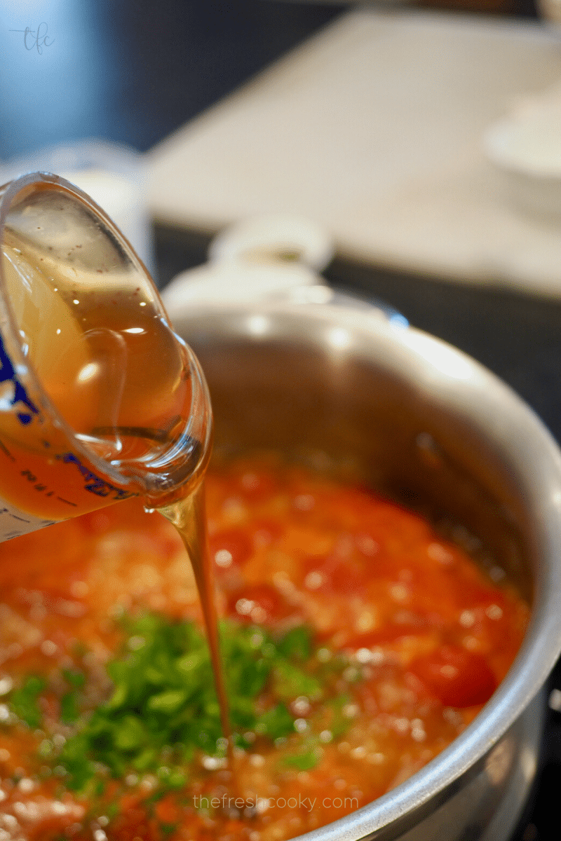 Adding honey to tomato soup mixture. 