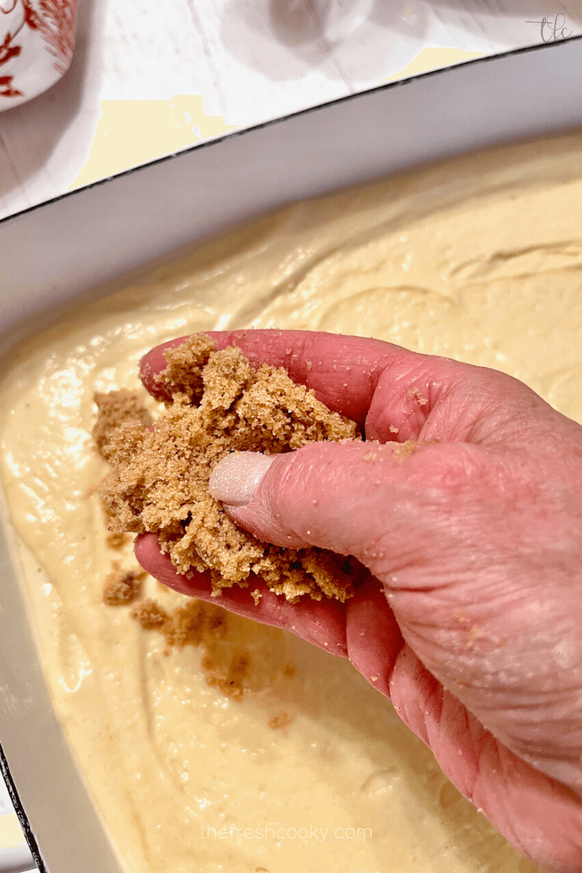 Adding streusel topping to top of cake. 
