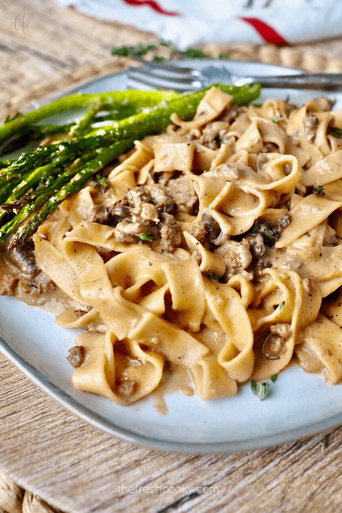 Instant Pot Ground Beef Stroganoff served on a plate with asparagus.